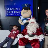 Two brothers smile with with Santa and Louie